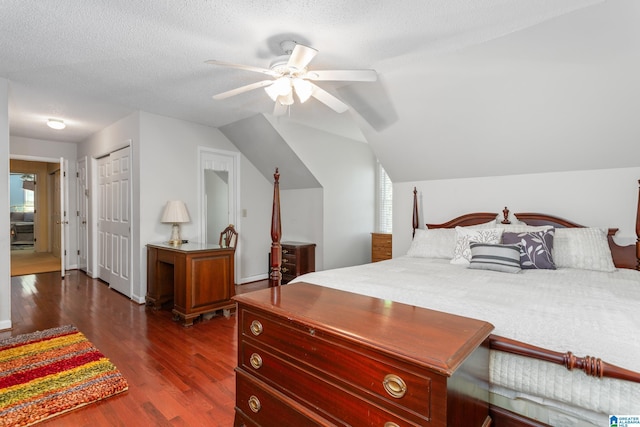 bedroom with ceiling fan, dark wood finished floors, a textured ceiling, a closet, and lofted ceiling