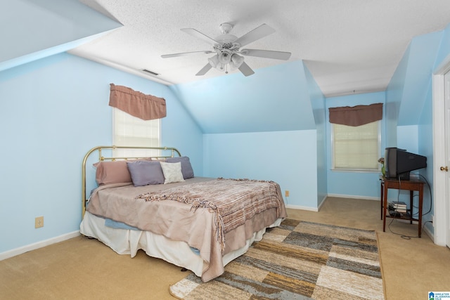 carpeted bedroom with lofted ceiling, baseboards, a textured ceiling, visible vents, and ceiling fan