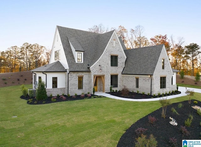 view of front facade with a front lawn and roof with shingles