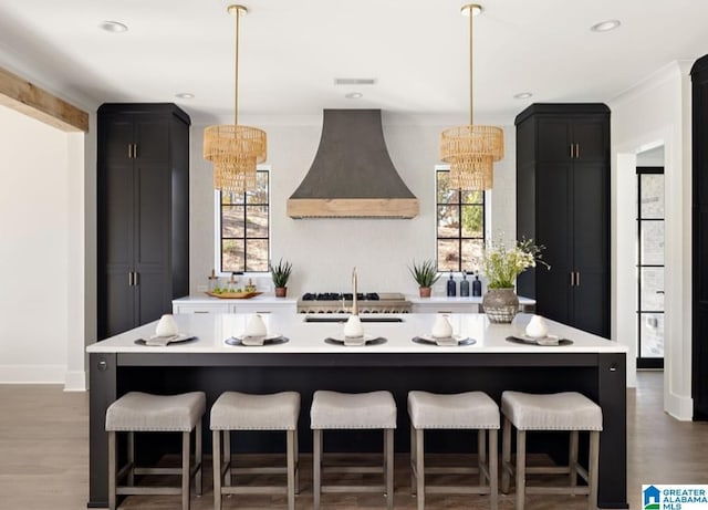 kitchen with light countertops, premium range hood, a chandelier, and dark cabinets