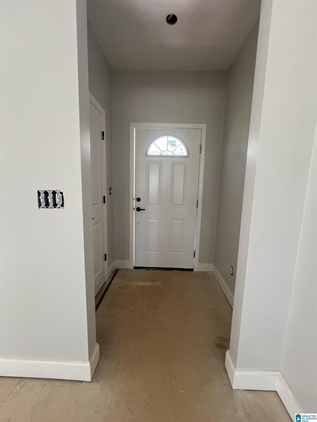 entryway with unfinished concrete flooring and baseboards