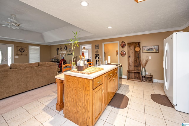 kitchen featuring light tile patterned floors, light countertops, freestanding refrigerator, a ceiling fan, and a sink