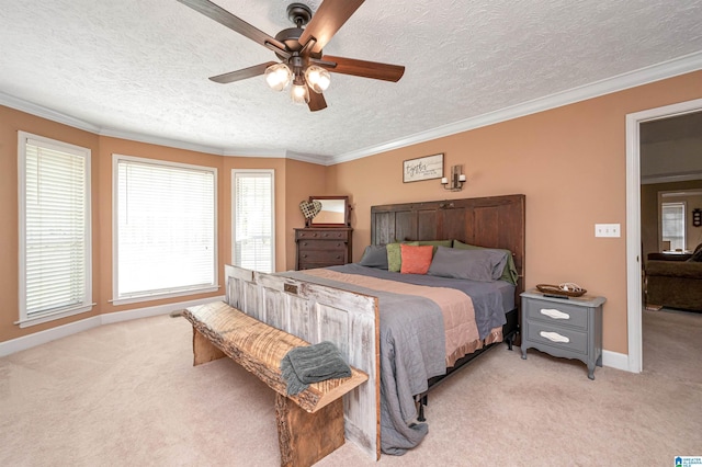 bedroom featuring baseboards, ceiling fan, a textured ceiling, crown molding, and light carpet