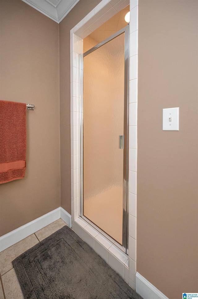 full bath featuring a shower stall, baseboards, ornamental molding, and tile patterned flooring