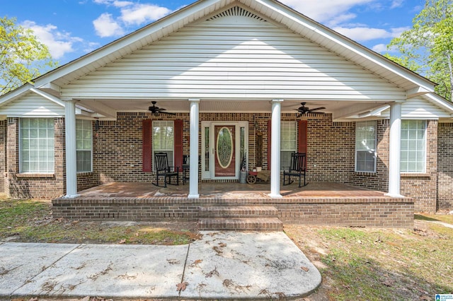 view of front facade featuring brick siding, a ceiling fan, and covered porch