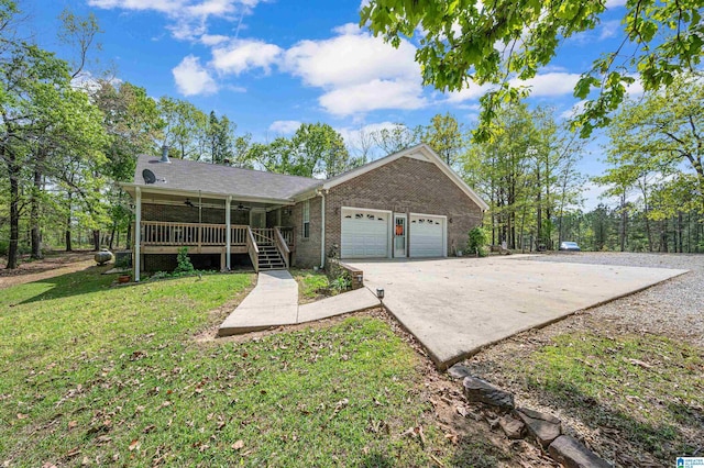 ranch-style home with ceiling fan, a front yard, brick siding, an attached garage, and driveway