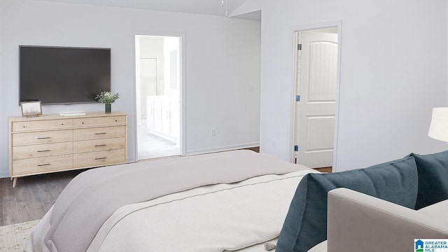 bedroom featuring dark wood-type flooring and ensuite bathroom