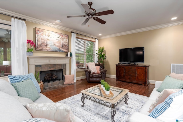 living room with ornamental molding, visible vents, ceiling fan, and wood finished floors