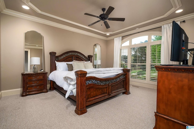 bedroom featuring ornamental molding, a tray ceiling, and carpet
