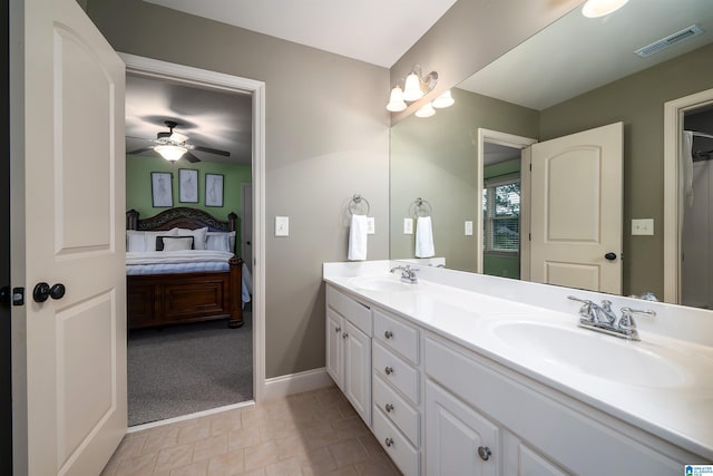 ensuite bathroom featuring double vanity, visible vents, a sink, and connected bathroom