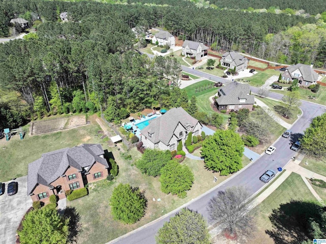 birds eye view of property featuring a wooded view and a residential view