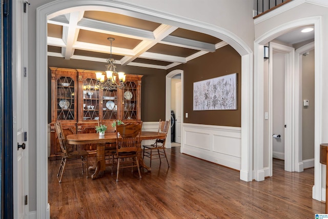 dining room with arched walkways, wood finished floors, an inviting chandelier, and beam ceiling