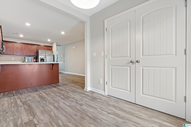 6106 Townley Ct, Mccalla, AL 35111 - kitchen with light wood-style flooring, a peninsula, stainless steel refrigerator with ice dispenser, light countertops, and baseboards