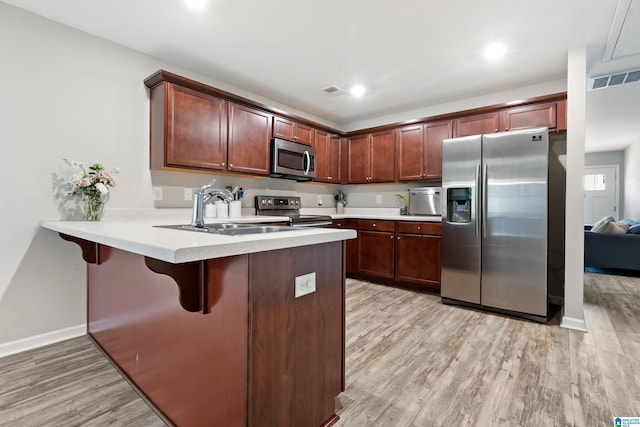6106 Townley Ct, Mccalla, AL 35111 - kitchen featuring a sink, light wood-style flooring, a peninsula, and stainless steel appliances