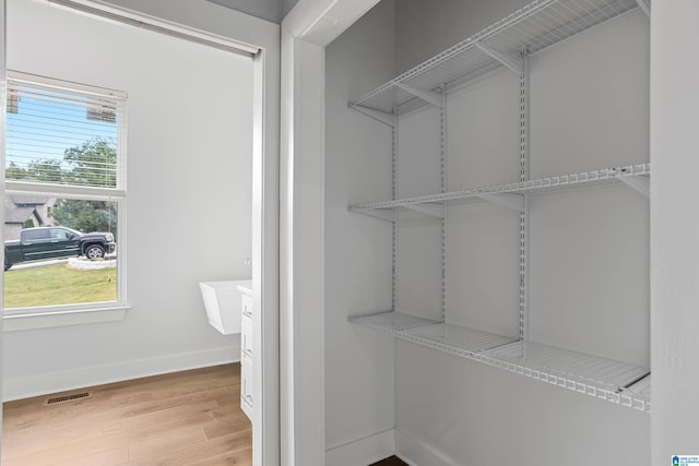 walk in closet with visible vents and wood finished floors