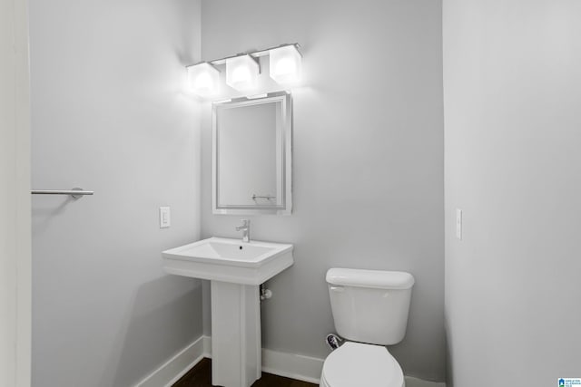 half bath with toilet and baseboards