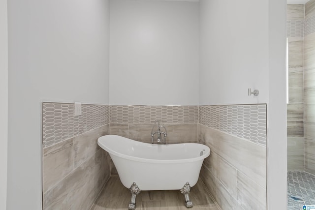 full bathroom with a freestanding bath and tile walls