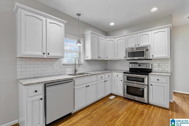 88 Glen Trce, Springville, AL 35146 - kitchen with light wood finished floors, a sink, white cabinets, and stainless steel appliances