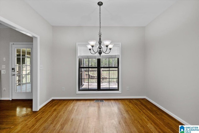 88 Glen Trce, Springville, AL 35146 - unfurnished dining area featuring wood finished floors, an inviting chandelier, baseboards, and visible vents
