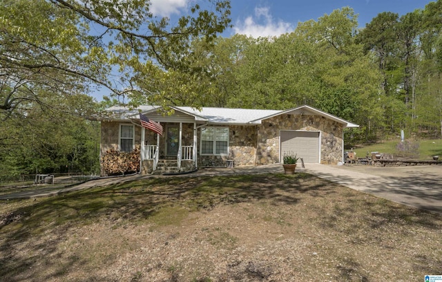 view of front facade featuring an attached garage, stone siding, and concrete driveway