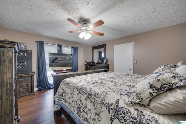 bedroom with a textured ceiling, wood finished floors, and ceiling fan