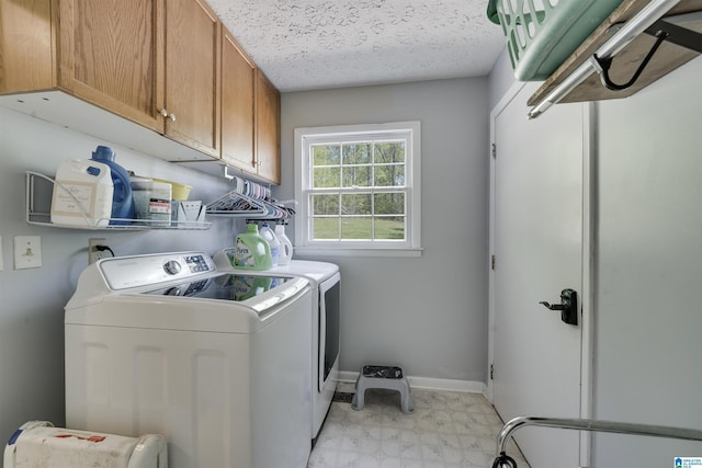 clothes washing area featuring baseboards, light floors, a textured ceiling, cabinet space, and washing machine and clothes dryer