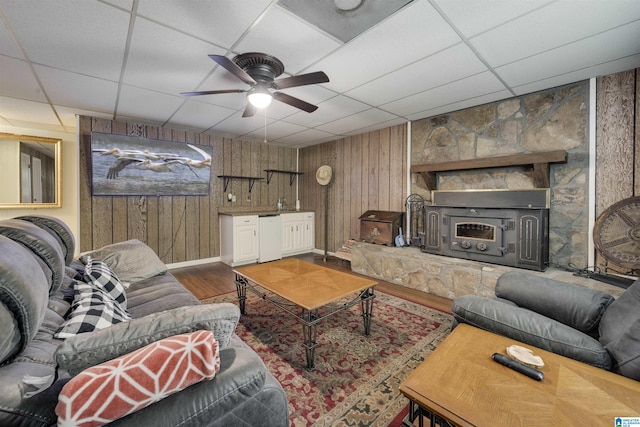 living room featuring wood walls, ceiling fan, a paneled ceiling, and wood finished floors