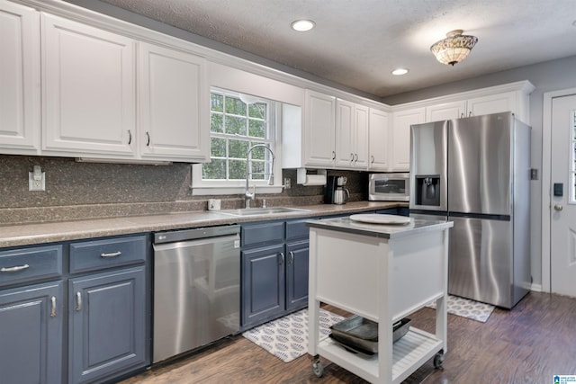 kitchen featuring a sink, white cabinets, blue cabinets, and stainless steel appliances