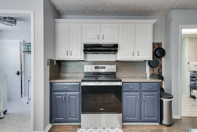 kitchen featuring white cabinets, under cabinet range hood, blue cabinets, and stainless steel range with electric cooktop