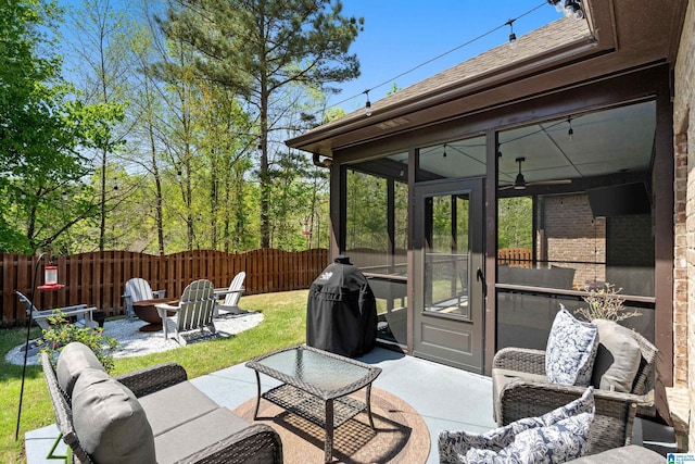 view of patio featuring a sunroom, area for grilling, an outdoor living space with a fire pit, and fence