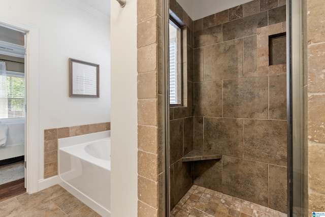 full bathroom featuring crown molding, a bath, and a shower stall