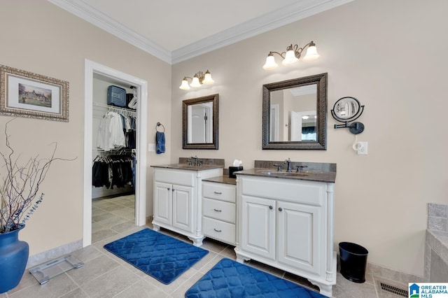 bathroom with vanity, ornamental molding, tile patterned floors, a walk in closet, and visible vents