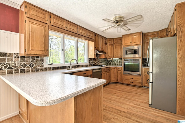 5000 Cameron Rd, Birmingham, AL 35242 - kitchen with stainless steel appliances, light countertops, a ceiling fan, a peninsula, and light wood-style flooring