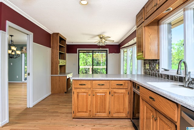 5000 Cameron Rd, Birmingham, AL 35242 - kitchen with brown cabinets, light countertops, a sink, light wood-style floors, and a peninsula