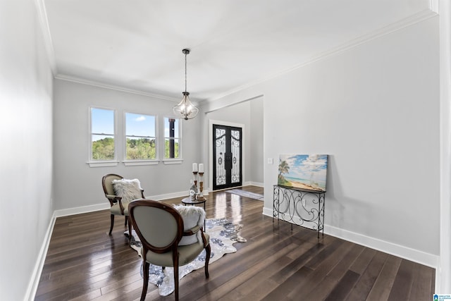 sitting room with dark wood-style flooring, ornamental molding, baseboards, and a chandelier