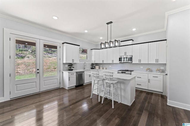 kitchen with tasteful backsplash, ornamental molding, dark wood finished floors, and stainless steel appliances