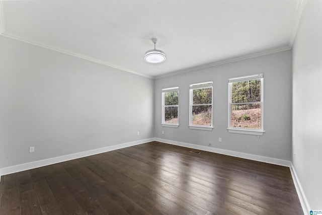 unfurnished room with dark wood-style flooring, ornamental molding, baseboards, and visible vents