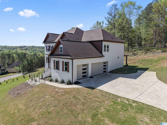 view of property exterior featuring a garage, a yard, and driveway