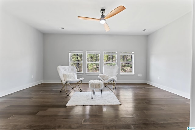unfurnished room with a ceiling fan, baseboards, dark wood finished floors, and visible vents