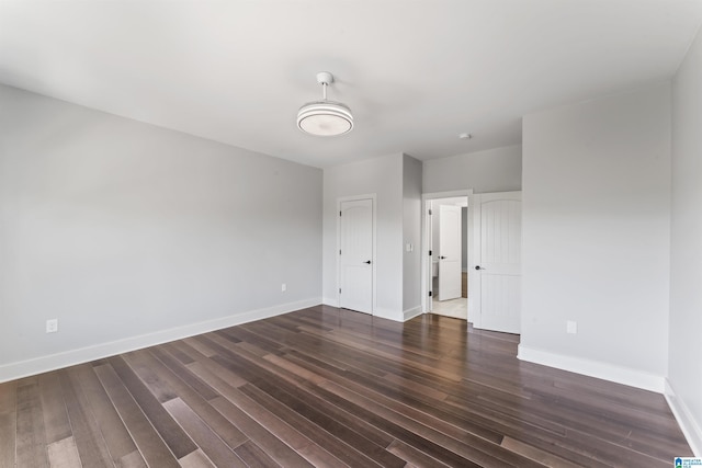 unfurnished bedroom with dark wood-style flooring and baseboards
