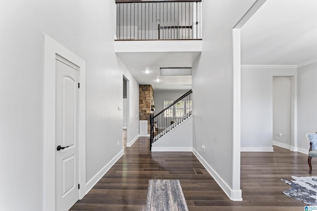 entryway with crown molding, baseboards, wood finished floors, and stairs