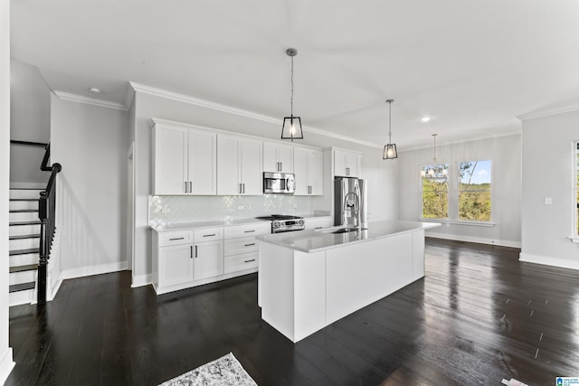 kitchen featuring light countertops, a sink, stainless steel appliances, a center island with sink, and decorative backsplash