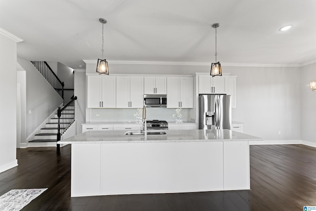 kitchen featuring dark wood-style flooring, crown molding, white cabinetry, a center island with sink, and stainless steel appliances