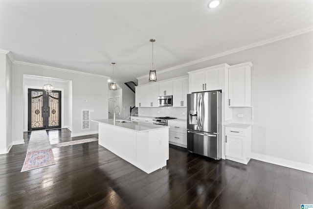 kitchen with crown molding, a kitchen island with sink, dark wood-type flooring, stainless steel appliances, and a sink