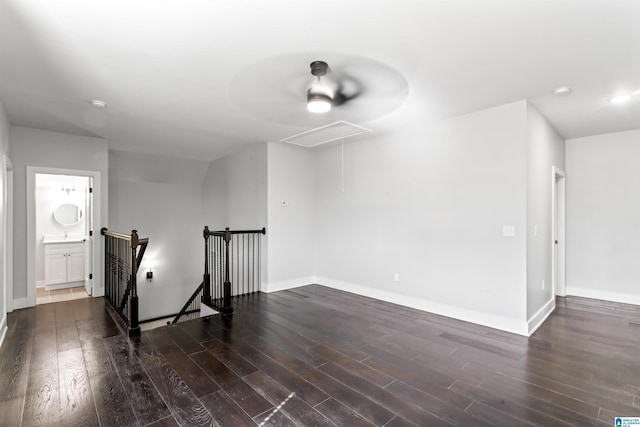 interior space with wood finished floors, attic access, and baseboards