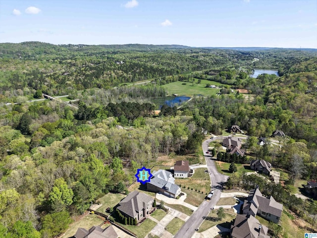 drone / aerial view featuring a forest view and a water view