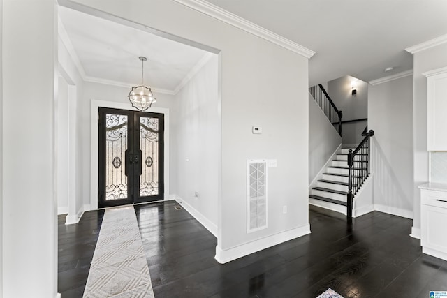 entrance foyer featuring dark wood-style flooring, a notable chandelier, crown molding, stairs, and visible vents