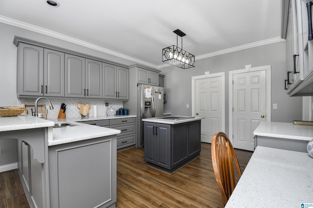 kitchen featuring decorative backsplash, a sink, ornamental molding, and gray cabinets