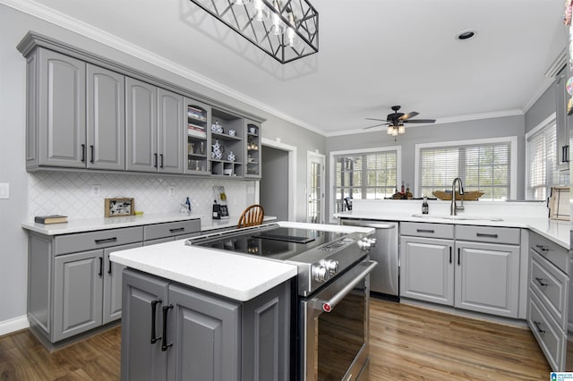kitchen with a sink, gray cabinets, a center island, and appliances with stainless steel finishes