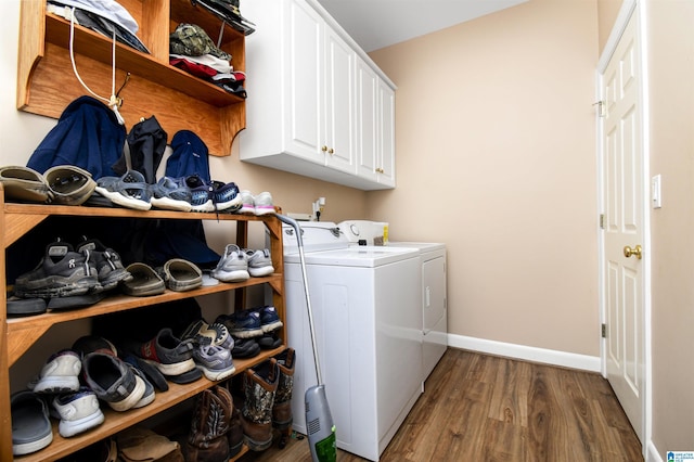 laundry room with separate washer and dryer, baseboards, cabinet space, and wood finished floors